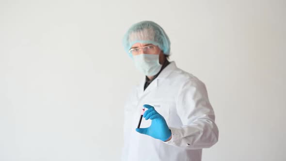 A Doctor in a White Coat and Protective Mask Shows a Sample of Infected Blood in a Test Tube