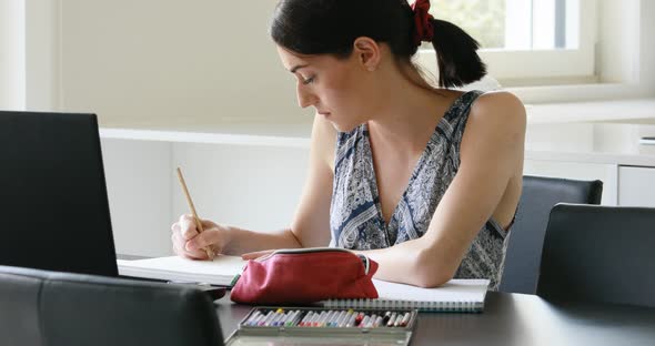 cute minute girl works or studies with computer and pencil