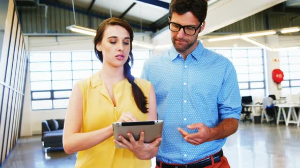 Business executives discussing over digital tablet