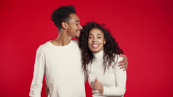 Portrait of young african american couple on red studio background. Love concept