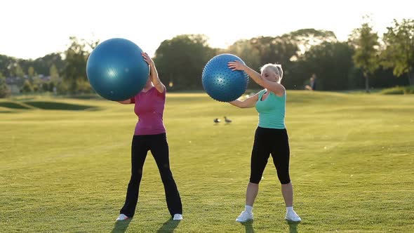 Smiling Adult Women Doing Ab Exercises with Balls