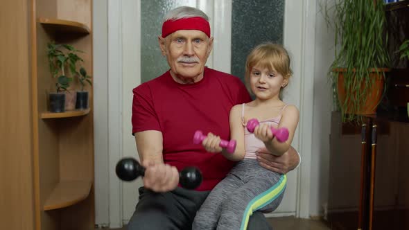 Child Kid Girl with Senior Grandfather in Sportswear Making Sports Workout Exercises with Dumbbells