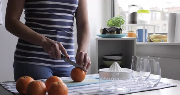 Woman cutting oranges on chopping board