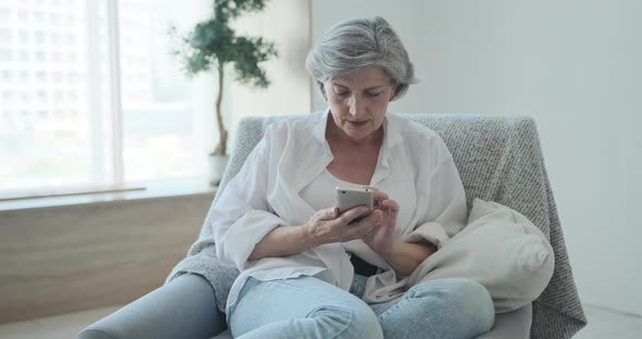 Overjoyed and Excited Mature Female Laughing Celebrating Online Lottery Win