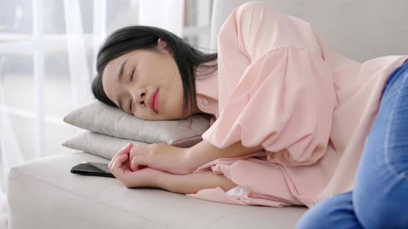 Close up Asian black hair woman lying down on sofa and sleeping at home