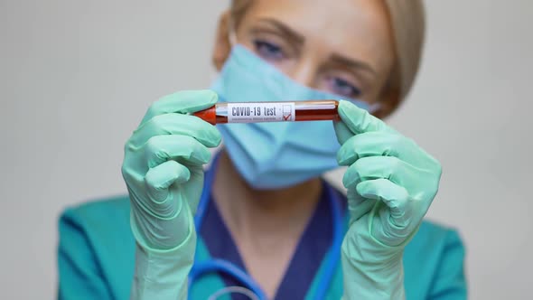 Medical Doctor Nurse Woman Wearing Protective Mask and Gloves - Holding COVID-19 Negative Blood Test