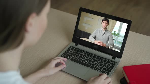 Woman Having Video Chat with Colleague at Table in Office, Closeup