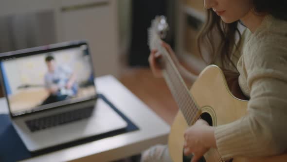 Young Asian Woman Playing Guitar at Home