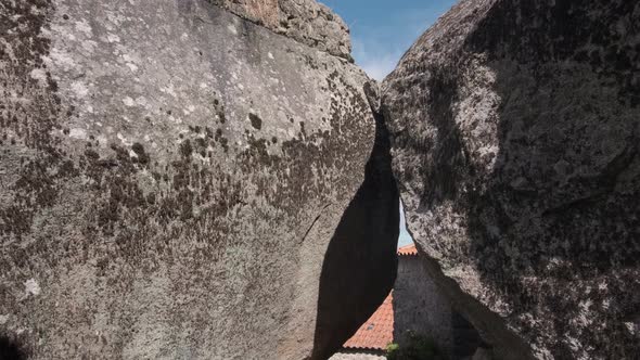 Two massive stones make a doorway on a cobblestone path leading to Monsanto Village.