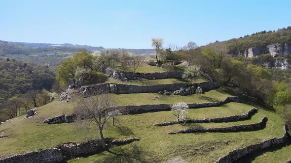 An Astounding Aerial Scenery Of A Terraced Hill Full Of Trees, Rocks And Plants