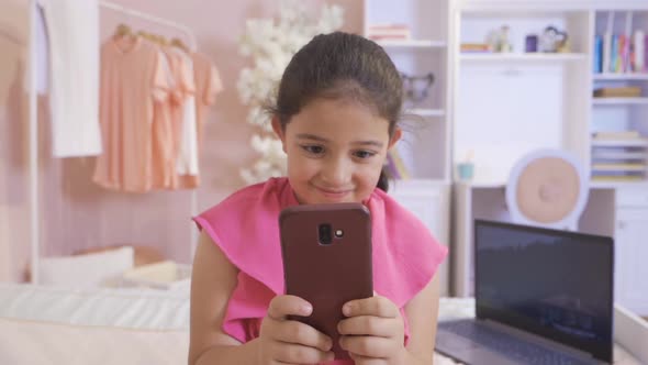 Little girl playing on the phone.