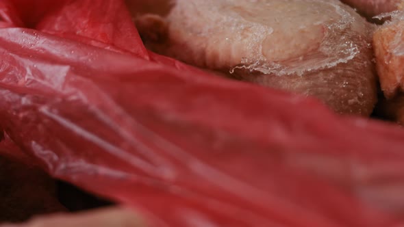 Closeup View of Hands in Gloves Packing Chicken Legs From a Box Into Individual Plastic Bags