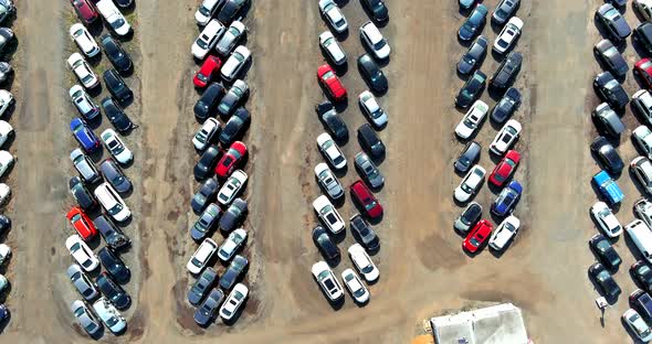 Top aerial view of auto auction many used car lot parked distributed in a parking.