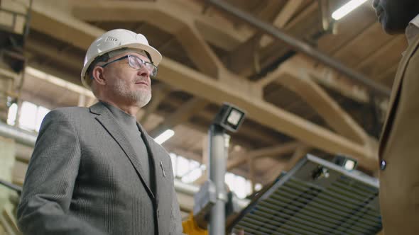 Senior Factory Engineer Giving Handshake to Colleague