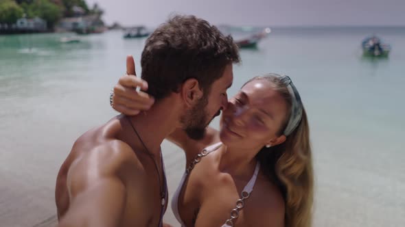 A Close Up Shot of a Couple Kissing Each Other While Standing on a Beautiful Beach