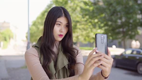 Young Asian Woman Takes Selfies Smartphone  Apartment Building Complex Background