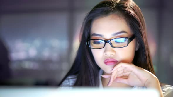 Closeup Portrait of Asian Young Female Businesswoman Searching Information Using Laptop at Late