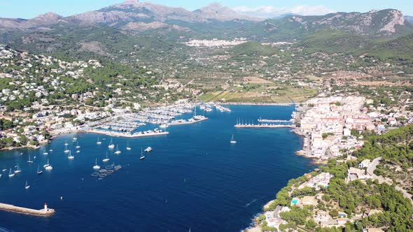 Port Andratx in Mallorca Spain with lighthouse point below on sunny day, Aerial panorama pan left vi