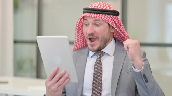 Portrait of Middle Aged Arab Businessman Celebrating on Tablet in Office