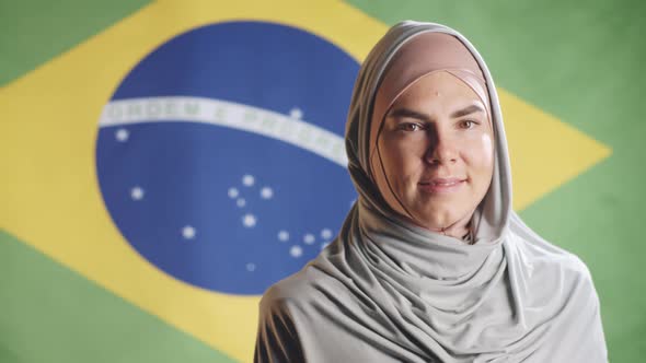 Portrait of Cheerful Woman in Hijab Posing on Brazilian Flag