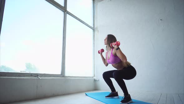 Strong Woman Doing Work Out in the Sport Studio. She Holding Dumbbells