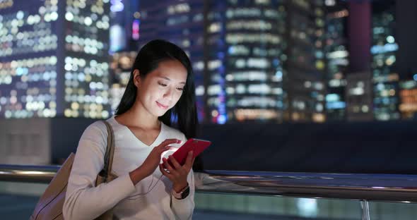 Woman use of mobile phone in city at night