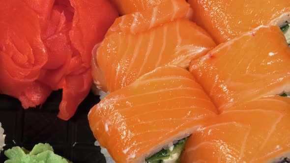 Sushi Rotates on a Plastic Box. Japanese Sushi Roll Set Philadelphia with Salmon