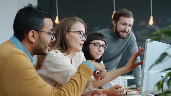 Slow Motion of Multi-ethnic Group of People Talking in Office Pointing at Computer Screen