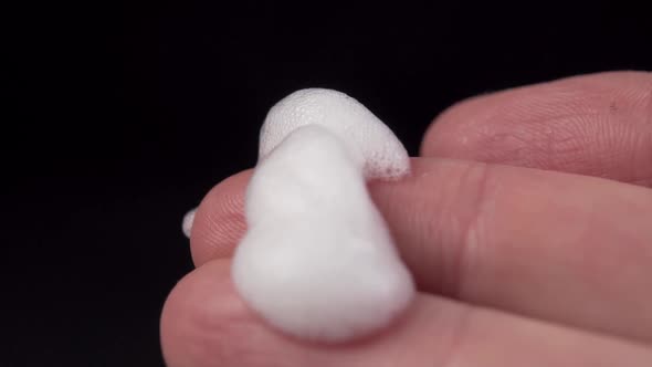 Foam falls on the finger in slow motion