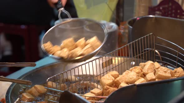 Deep frying stinky tofu popular Taiwanese dish cuisine street food at night market, must eat when vi