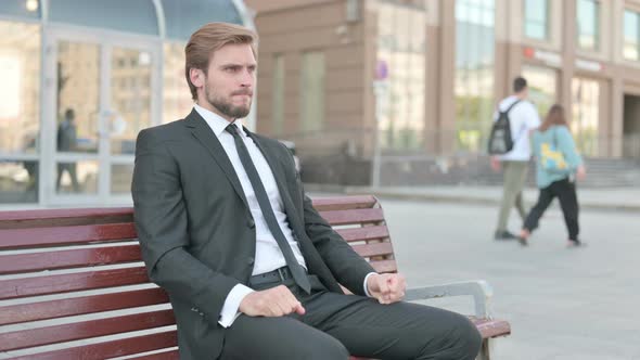 Tense Businessman Feeling Frustrated While Sitting Outdoor on Bench