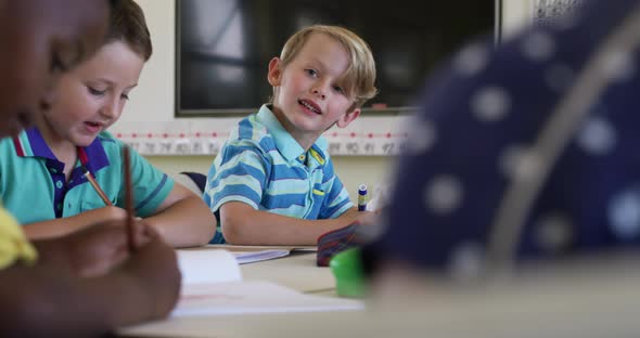 Boy smiling while studying in the class