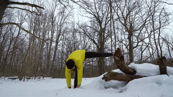 Fit Man Exercising Stretching Legs in Winter Forest