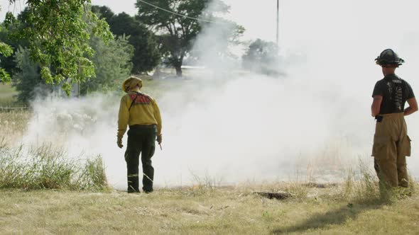 Firemen lighting grass on fire