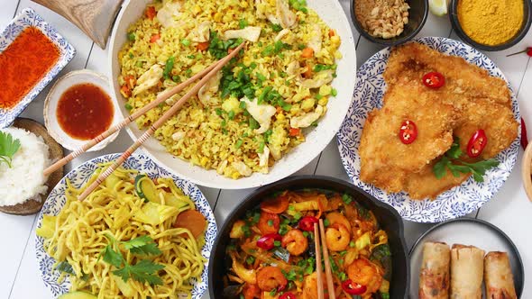 Plates, Pans and Bowls Full of Noodles Chicken Stir Fry and Vegetables