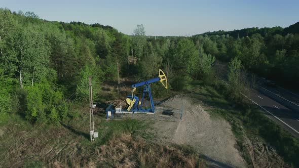 Pumpjack Extracting Crude Oil From An Oil Well Near Campina, Romania. aerial drone ascend