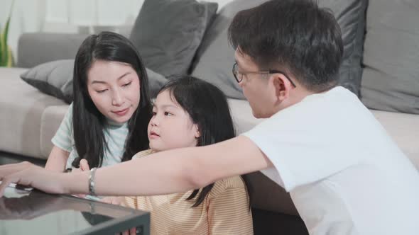 Happiness Asian family and daughter enjoy using tablet at home