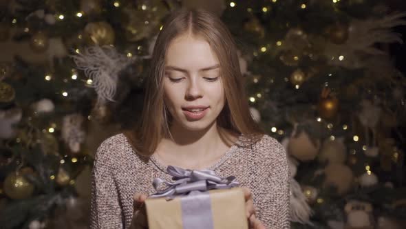 Adorable, Shy Young Girl Giving Christmas Present