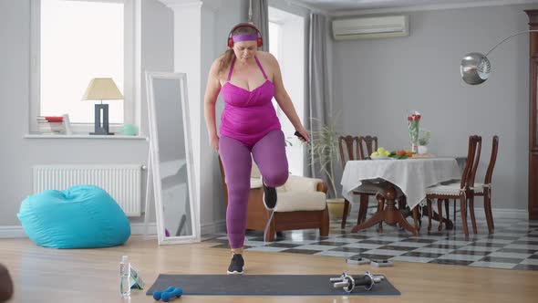 Front View Portrait of Obese Caucasian Woman Jumping Using Skipping Rope at Home