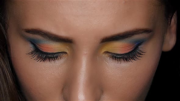 Girl with a Beautiful Bright Make Up and Sharp Eyes Looking Intently Up. Close Up. Slow Motion