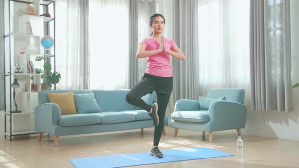 Young Asian Woman Doing Yoga At Home