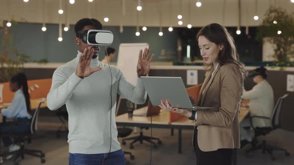 African American Businessman Testing a VR Simulator Headset and Gesturing in the Air While His