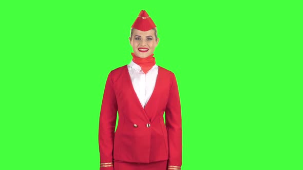 Stewardess in a Red Suit Winks a Slight Flirt Sends an Air Kiss. Green Screen