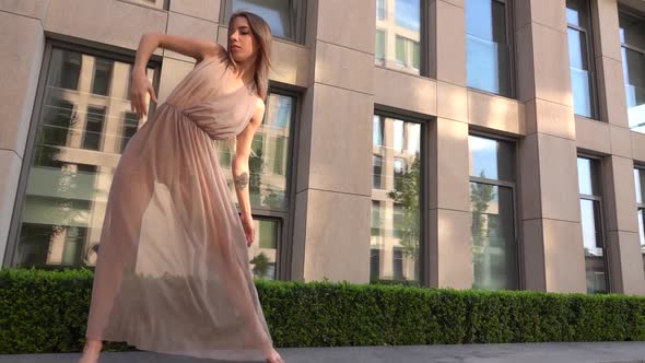 Beautiful Young Girl Dancing on the Street of a Modern Building of a Business Center. Slow Motion.