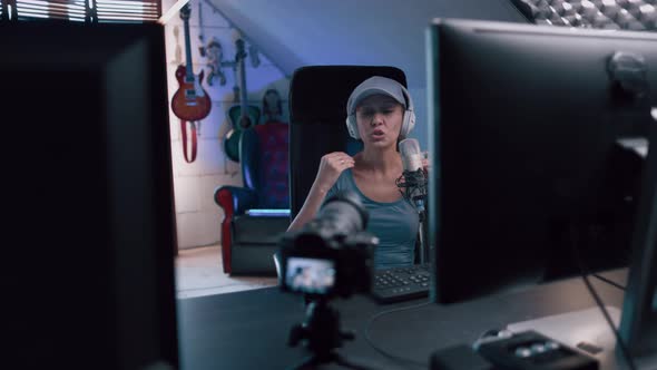 Beautiful Woman In A Cap And White Headphones Leads A Live Stream