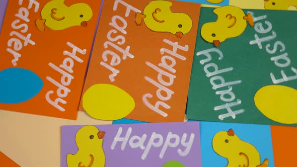 Multicolored cards with  paper Easter chickens and eggs, background