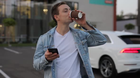 Man Drinking Coffee in City Using Smartphone