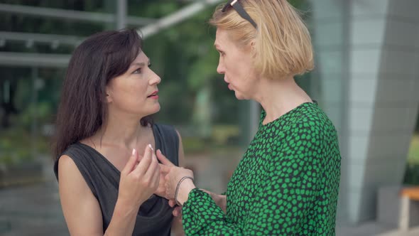 Portrait of Two Women Talking Turning Pointing at Camera Sneering in Slow Motion