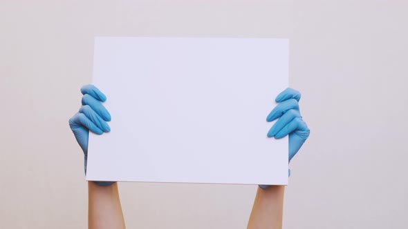 Woman Hands in Medical Gloves with White Poster