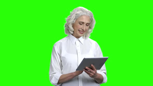 Smiling Senior Woman Using Digital Tablet